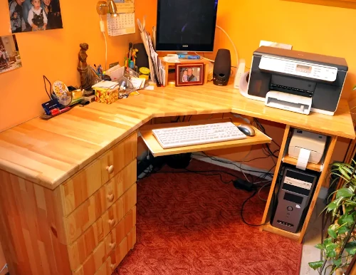 A képen egy fából készült íróasztal látszik fikókos résszel, billentyűzet-, monitor- és számítógéptartóval.